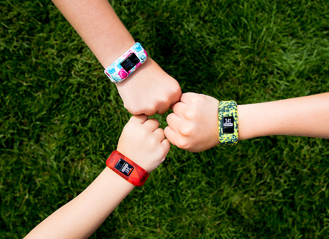 Three kids arms in a circle with Garmin activity trackers round wrist